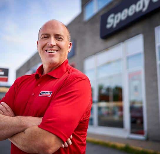 Employee Speedy Glass Speedy Glass technician standing proud in front of a service centre