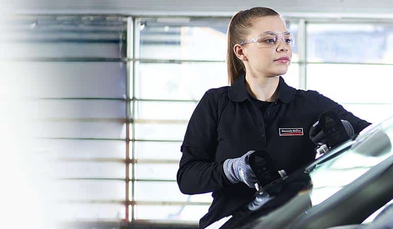 A Speedy glass employee replaces a windshield