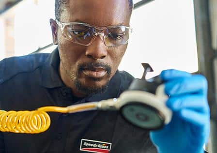 A Speedy glass employee repairs a windshield