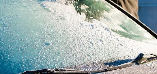 A person defrosts a windshield